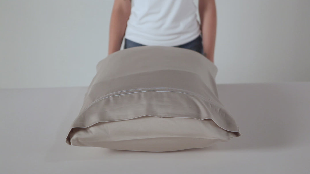 Front view of pillow with Premium Bamboo Sheet Set pillowcase showcasing smooth cooling bamboo fabric in beige on a white surface