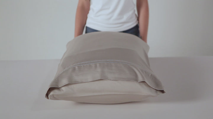 Front view of pillow with Premium Bamboo Sheet Set pillowcase showcasing smooth cooling bamboo fabric in beige on a white surface